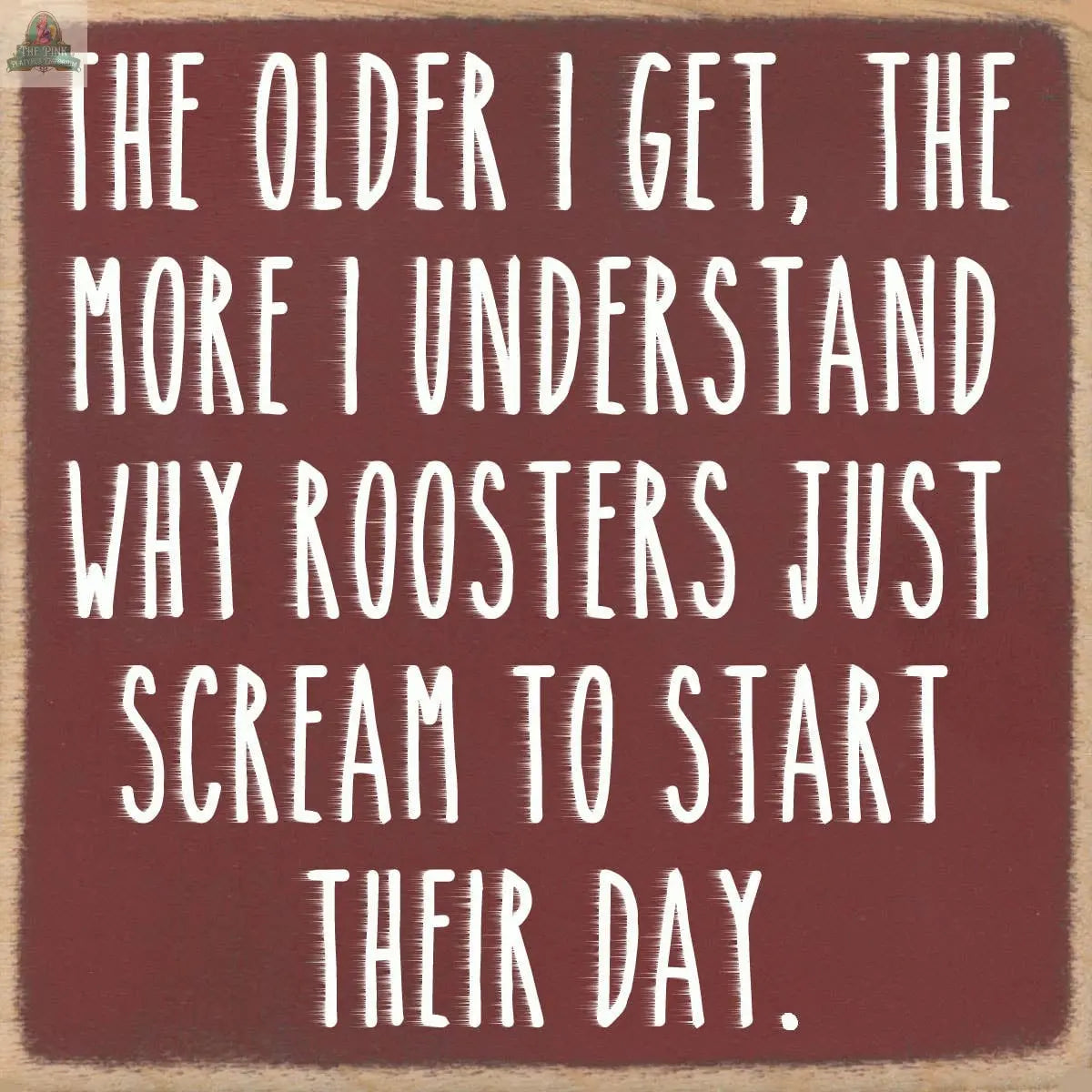 White text on a brown background reads: The older I get, the more I understand why roosters just scream to start their day—Pink Platypus Emporium's 4X4-Roosters, a charming wooden block sign perfect for seasonal decor.