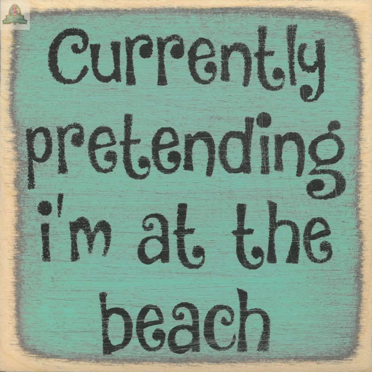 The Pink Platypus Emporium 4X4-Currently Pretending sign features playful black text on a teal wooden block, reading “Currently pretending I’m at the beach”—a fun touch for any home décor lover.