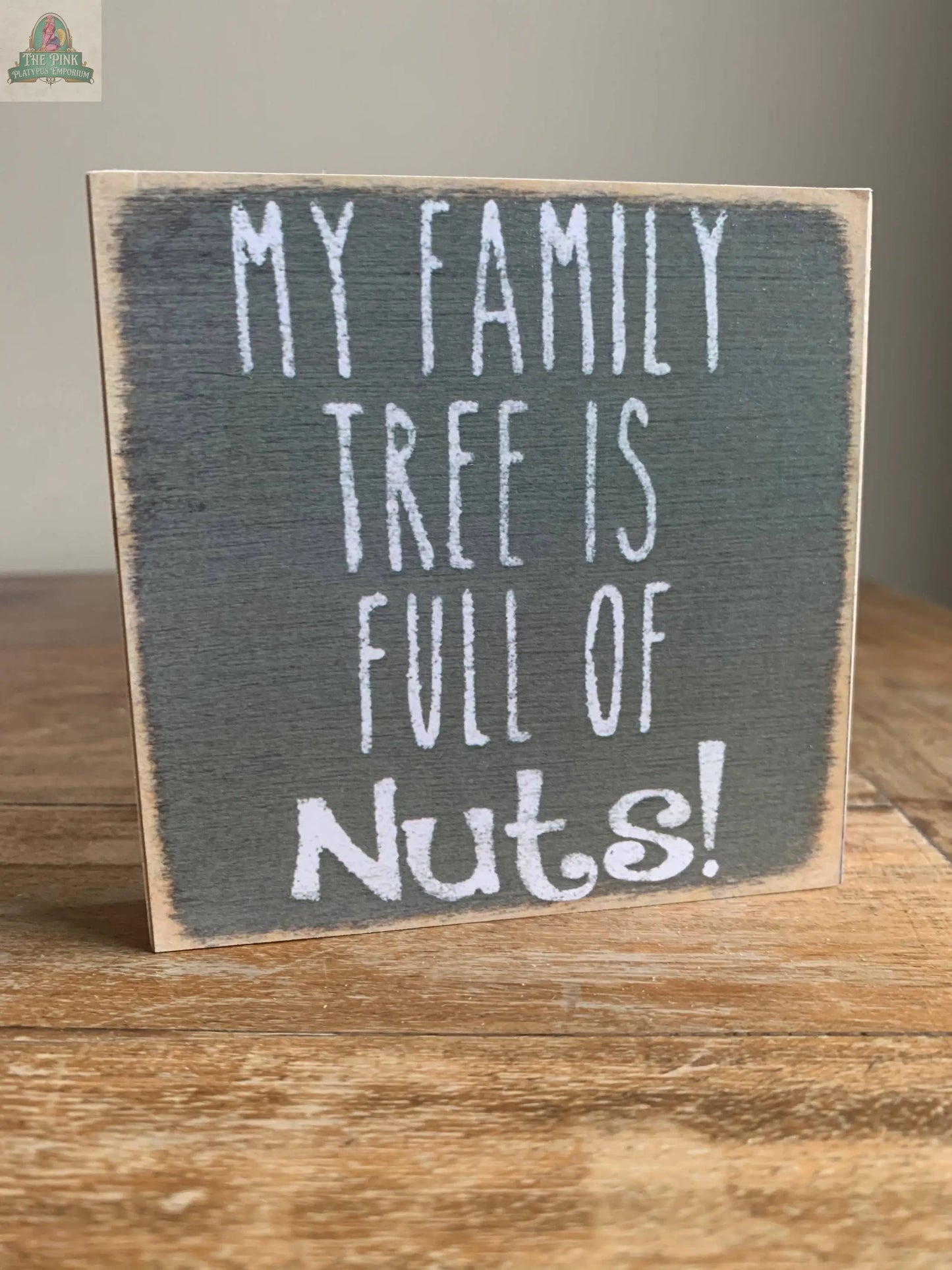The Pink Platypus Emporium 4X4-Family Tree Nuts wooden block sign features "MY FAMILY TREE IS FULL OF Nuts!" in playful white letters on a dark background—an ideal quirky home decor accent or fun seasonal sign.