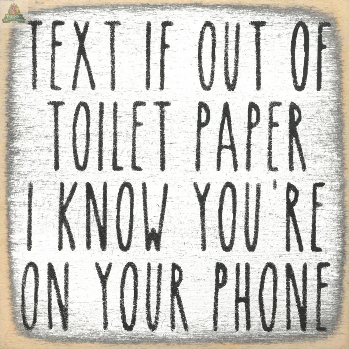 The Pink Platypus Emporium 4X4-Text Toilet Paper wooden block sign features bold uppercase text—“Text if out of toilet paper. I know you’re on your phone.”—on a textured white background, adding quirky charm to any bathroom décor.