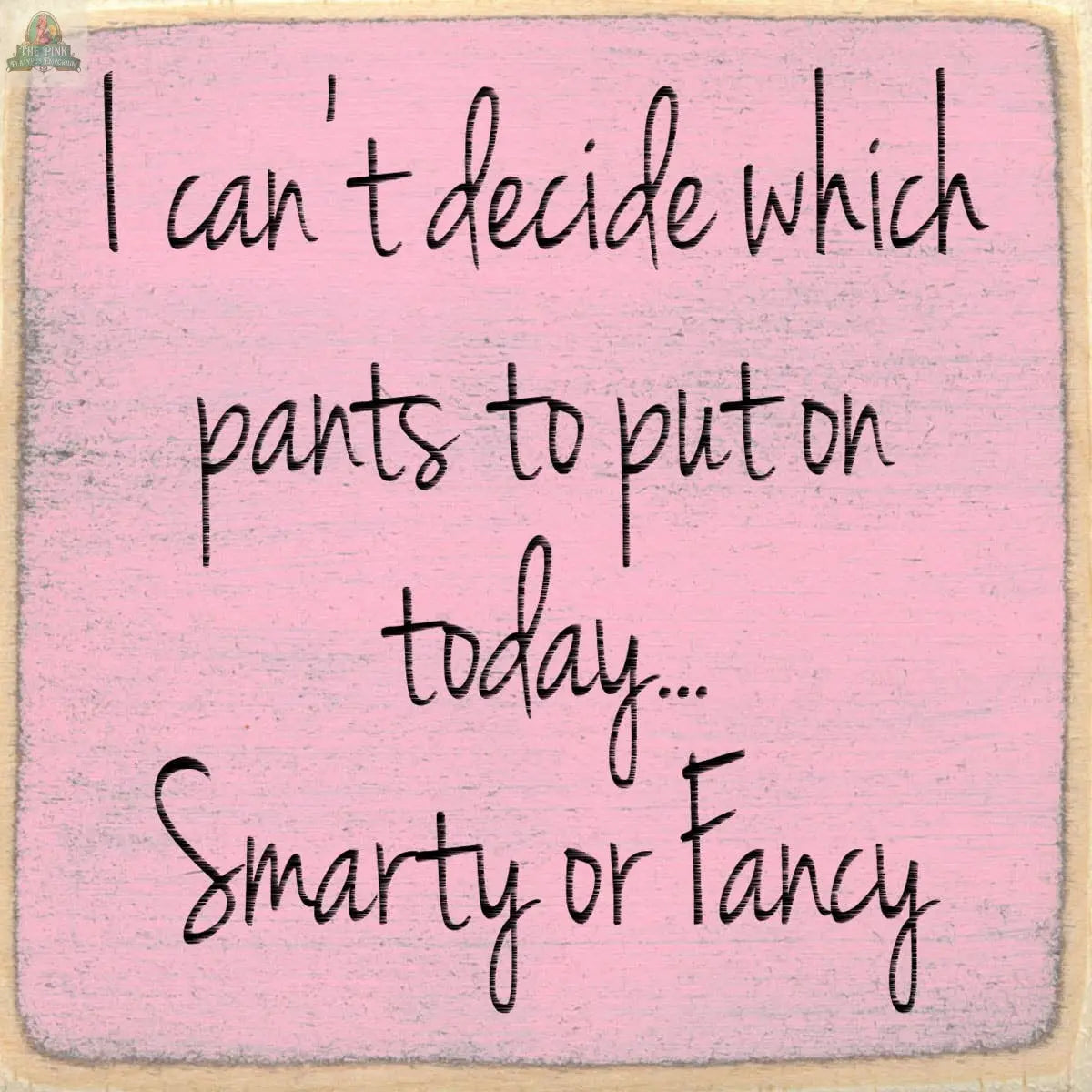 Text on a faded pink background reads: I can't decide which pants to put on today... Smarty or Fancy. The Pink Platypus Emporium 4X4-Smarty Or Fancy wooden block sign adds a playful, whimsical touch with its handwritten style.