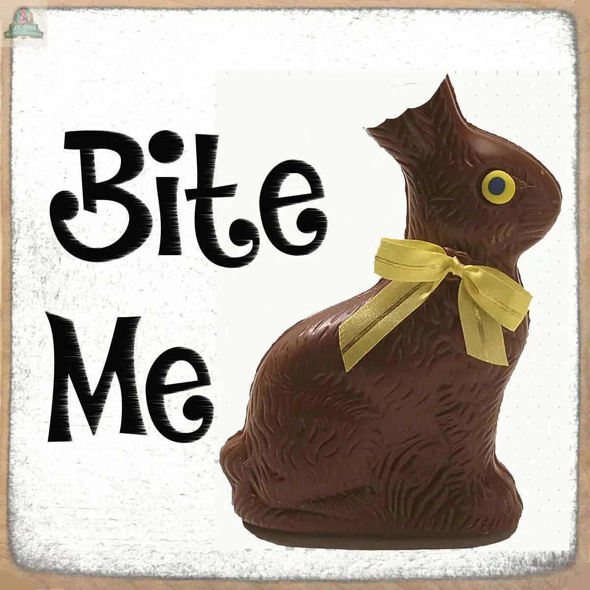 The Pink Platypus Emporium Bite Me Chocolate Rabbit Sign features a chocolate bunny with a missing ear and yellow ribbon beside bold "Bite Me" text on a white background—an ideal gift for chocolate lovers.