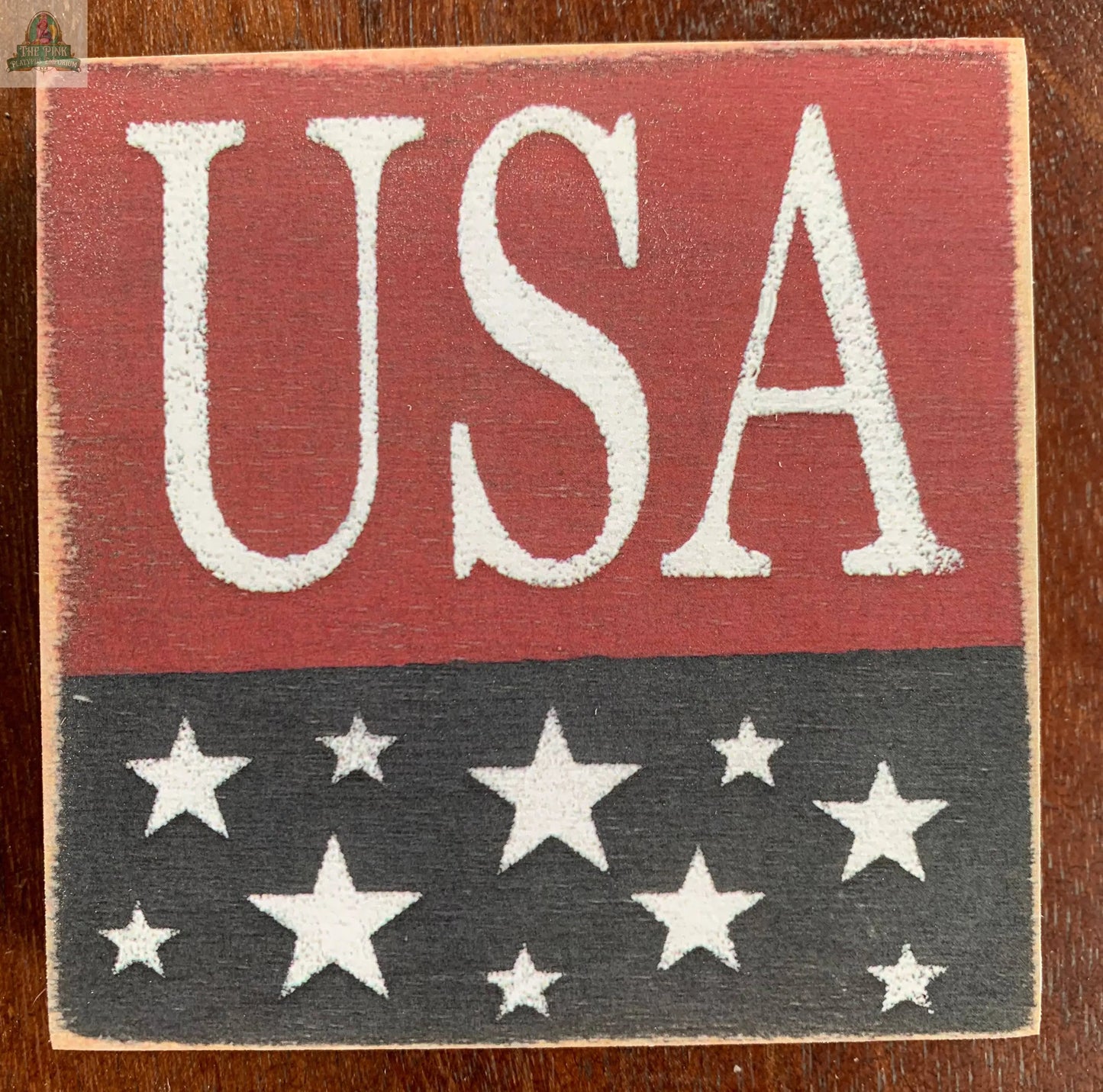 Showcasing "USA" in white on red, above a black background with white stars, the USA Wood Sign by Pink Platypus Emporium makes a standout patriotic decor piece.