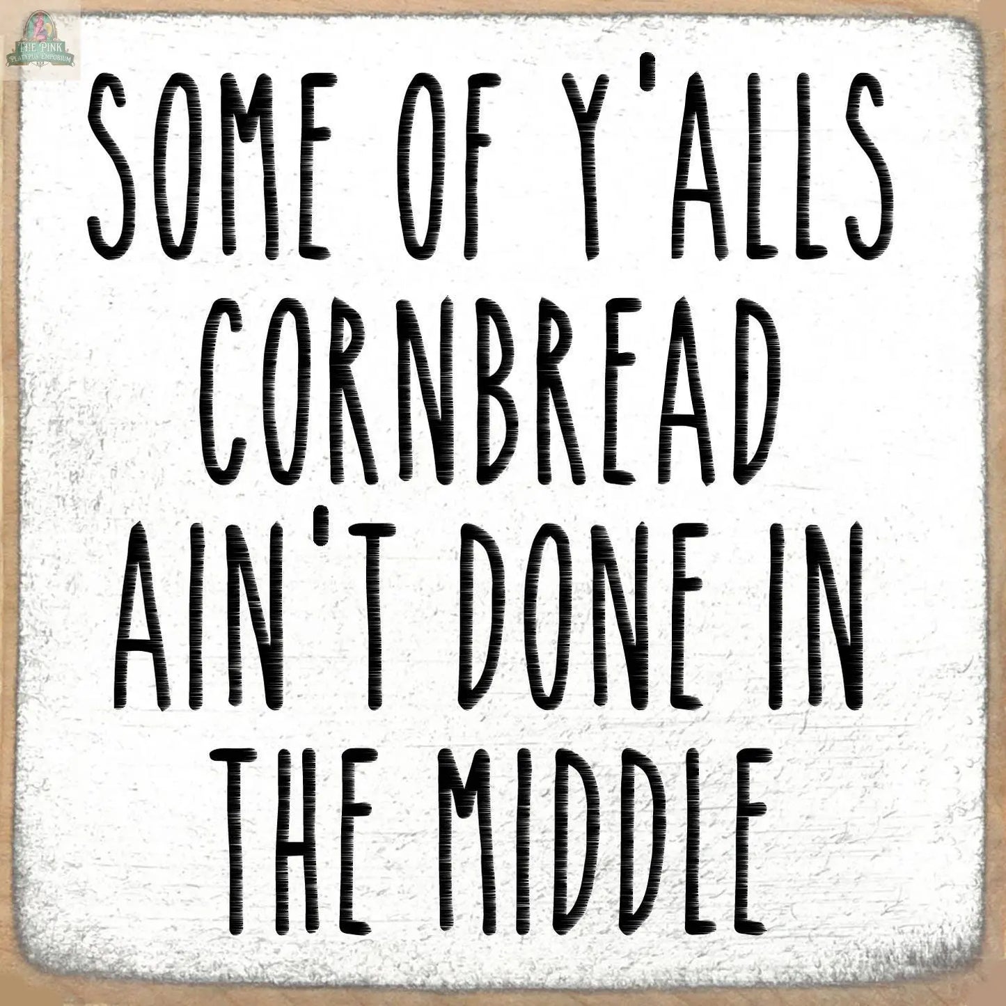 The Pink Platypus Emporium 5X5-Cornbread block sign features "Some of yalls cornbread aint done in the middle" in bold black text on a textured white background—a fun, humorous accent for your home decor.