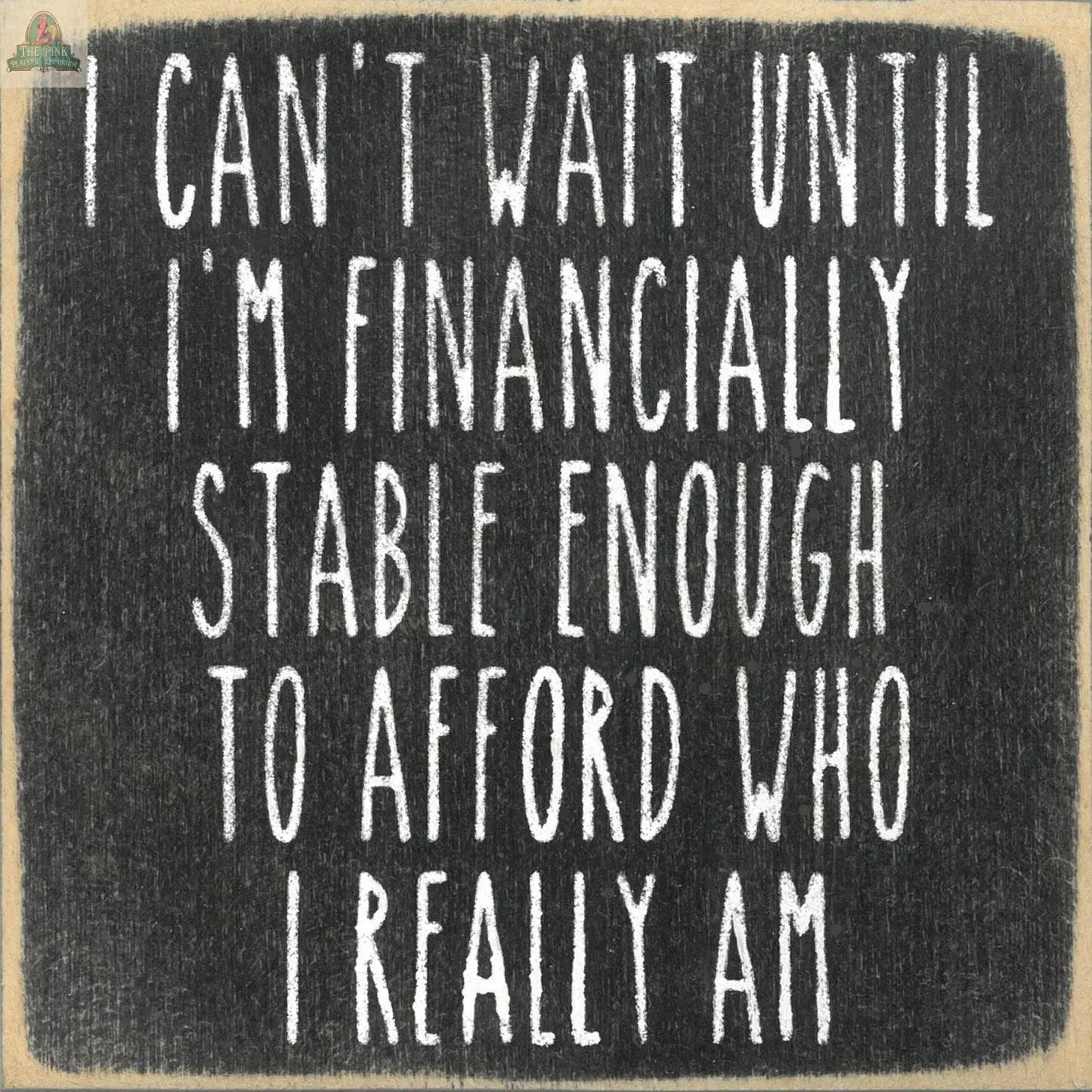 The "I can't afford who I really am" sign from Pink Platypus Emporium features white text on a chalkboard-style black background—perfect for home decor or as a unique handmade wooden gift.