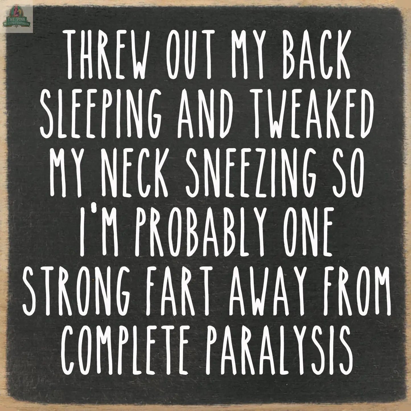White text on the Pink Platypus Emporium 5X5-Paralysis sign reads: Threw out my back sleeping and tweaked my neck sneezing, so I’m one strong fart from paralysis—a perfect touch for home decor or to pair with seasonal block signs.