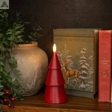 A 7" RED 3D FLAME SMOOTH TREE CANDLE glows on a wooden shelf, alongside a rustic beige vase with greenery, the book "FAWNS IN THE WILD" with a deer cover, and a red hardcover book for a vintage-inspired display.