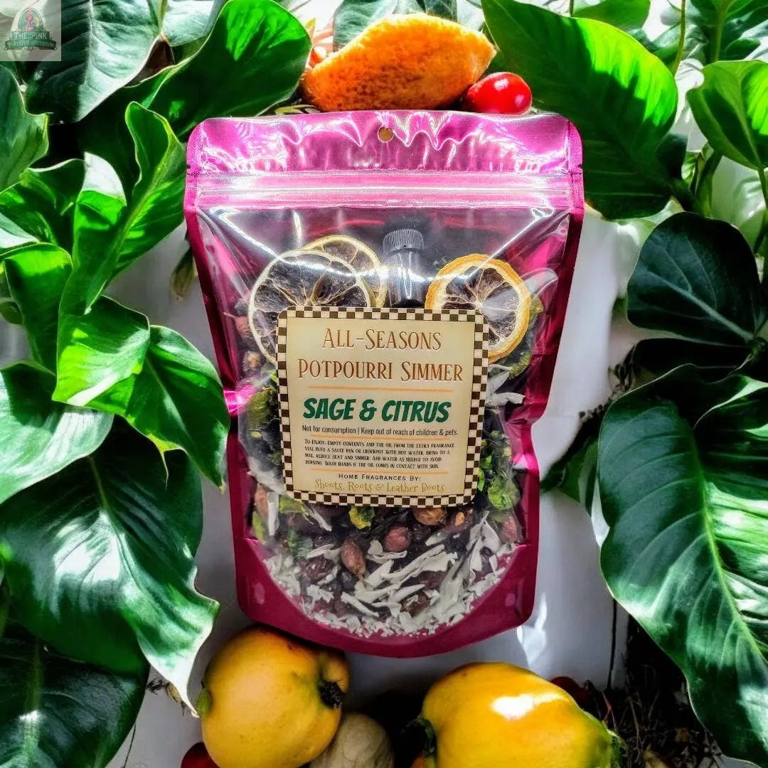 The All-Season Simmering Potpourri - Sage & Citrus, 4 oz., features a bright blend of dried botanicals in clear packaging among green leaves and citrus fruits—a refreshing home freshener for any space.