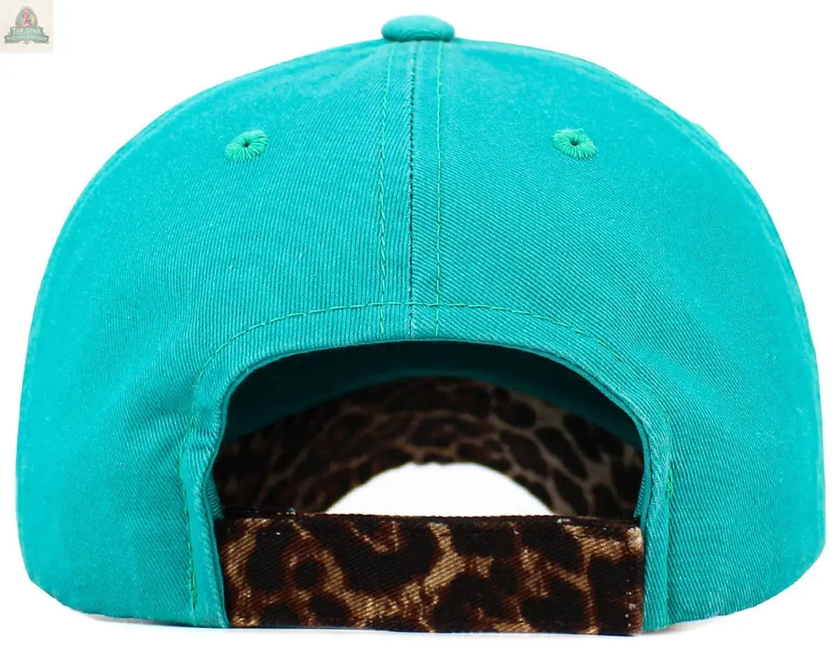 The Camping Queen Vintage Ballcap: HPK by Pink Platypus Emporium is a turquoise women’s baseball cap seen from the back, featuring an adjustable strap with a brown and black leopard print—ideal for vintage camping style fans.