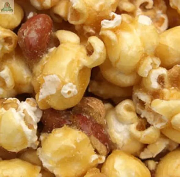 A close-up of caramel popcorn blended with whole roasted peanuts, glistening with caramel—an irresistible treat enhanced by the warm, sweet scent of Caramel Corn Atomizer Oils filling the air.