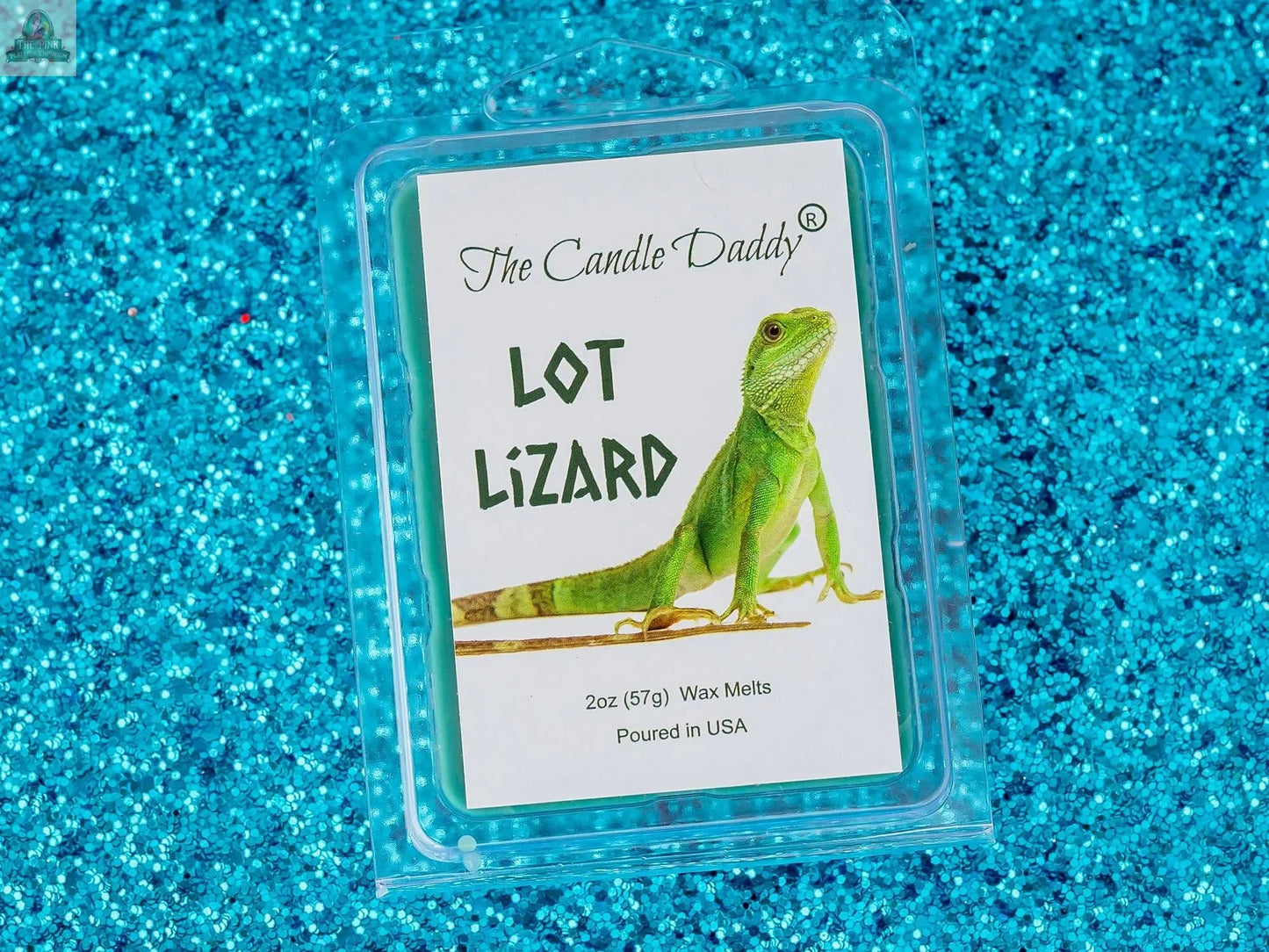 A package of LOT LIZARD - PINE AIR FRESHENER SCENTED WAX MELT, featuring a green lizard on the label, is shown against a sparkling blue glitter background—ideal for aromatherapy fans.