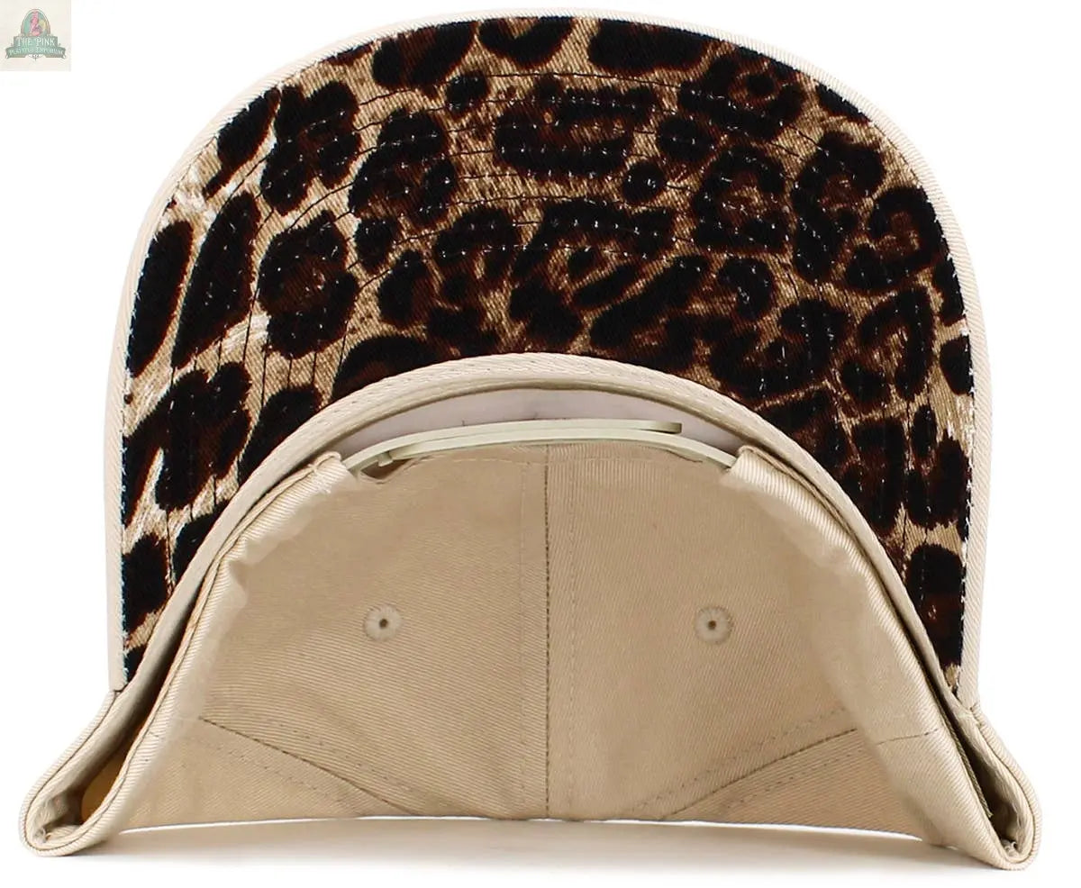The Pink Platypus Emporium Leopard Heart Snapback Hat is a women’s beige cap with a leopard print under the brim, adding subtle wild style to any look.