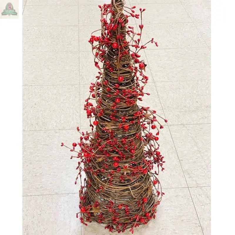 The 21" Mixed Berry Cone Tree with rust stars, featuring twisted brown vines and artificial red berries, adds holiday charm as it sits on a light-colored tiled floor.