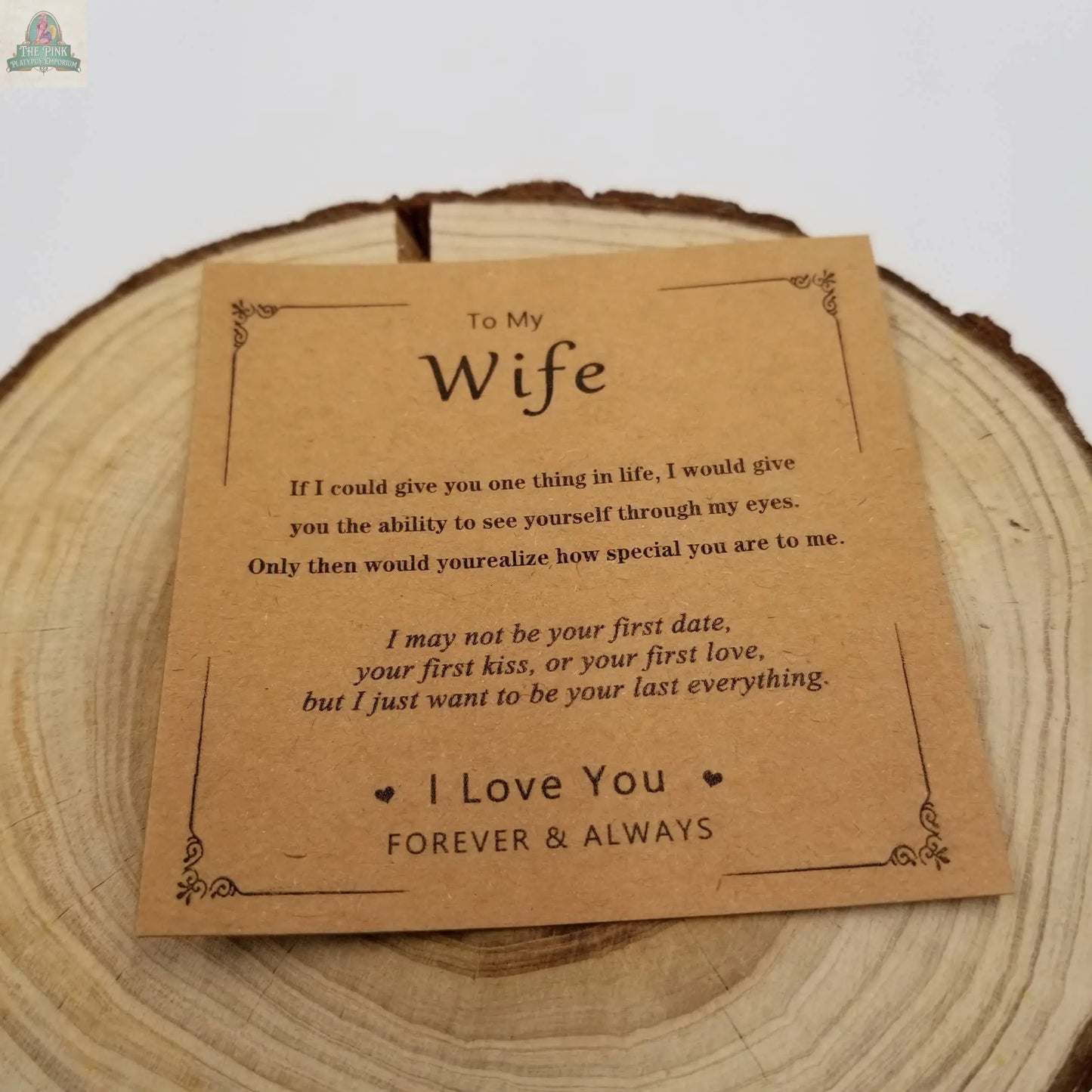 A brown card on a wooden surface reads: To My Wife... I Love You FOREVER & ALWAYS, paired with the Natural Rhodonite Bracelet Valentine'S Day Gift For Wife by Pink Platypus Emporium for love and healing.