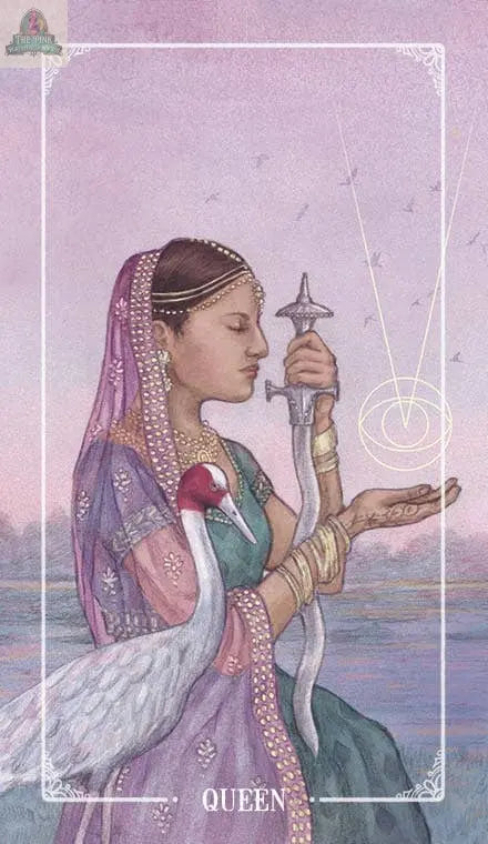 A woman in traditional South Asian dress meditates, sword upright, with a white crane by her side and geometric Tarot lines on her palm. The card reads “QUEEN.” Ostara Tarot by pink platypus emporium.