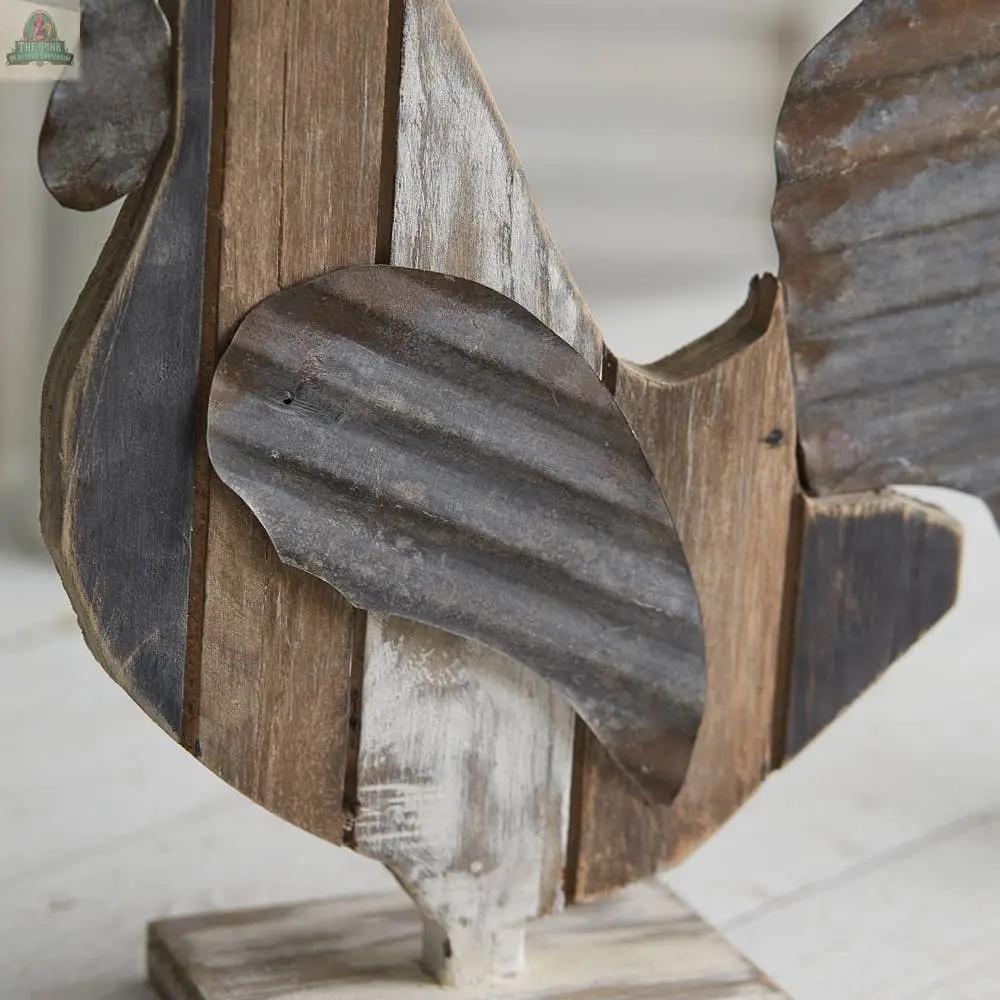 Close-up of the Reclaimed Wood Rooster, a rustic sculpture made from reclaimed wood and corrugated metal on a wooden base—ideal for farmhouse decor and shown on a light-colored surface.