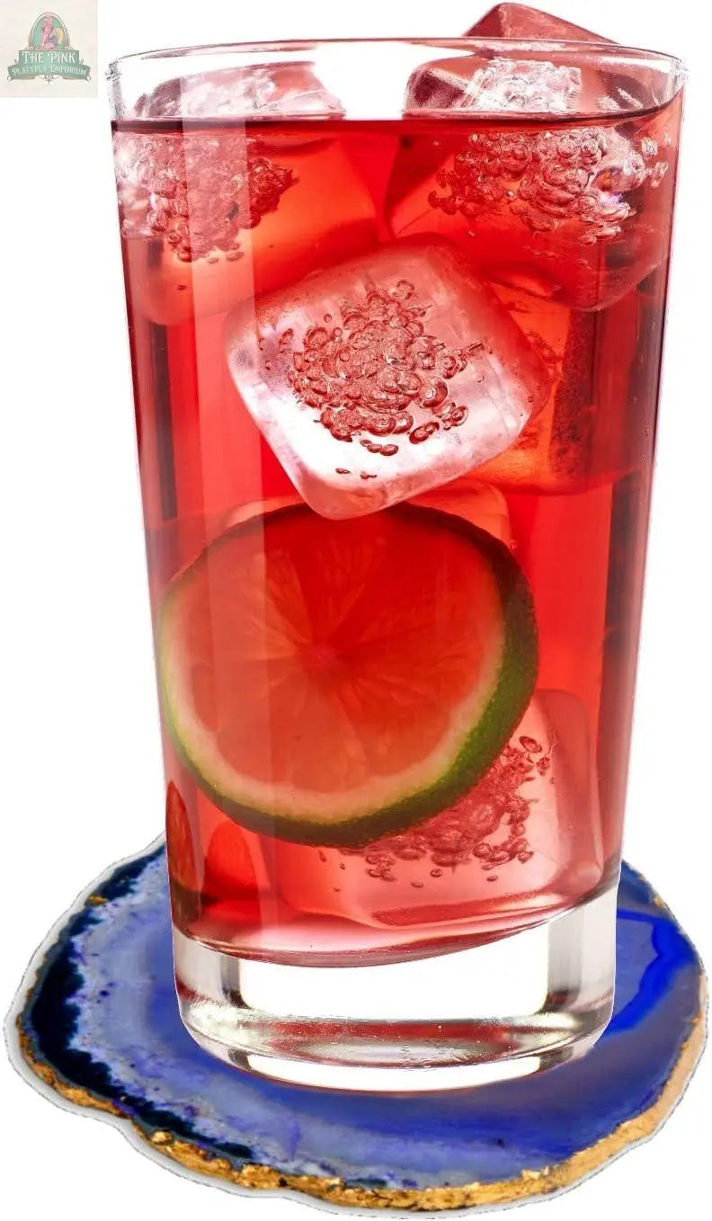 A tall glass with a red drink, ice, and lime sits on Pink Platypus Emporium's Blue Agate Coasters-Set of 4, adding elegance and natural stone beauty to your table.