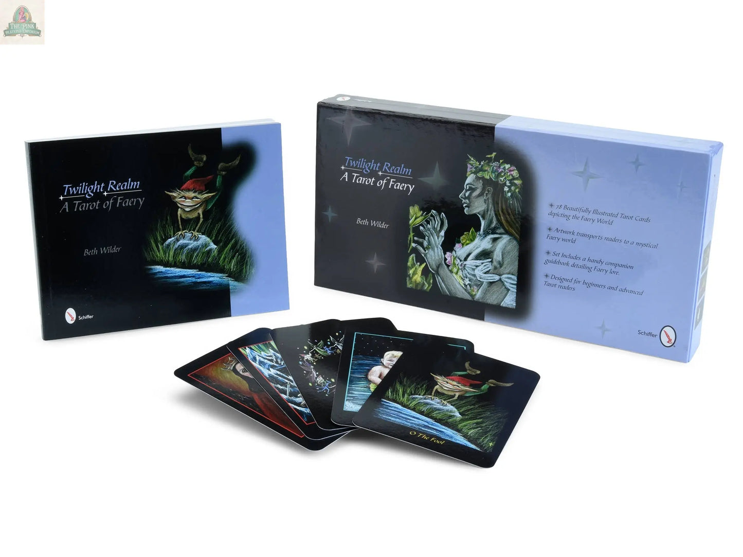 The Twilight Realm: A Tarot of Faery by pink platypus emporium is shown with its box, guidebook, and several beautifully illustrated, faery-inspired cards displayed in front.
