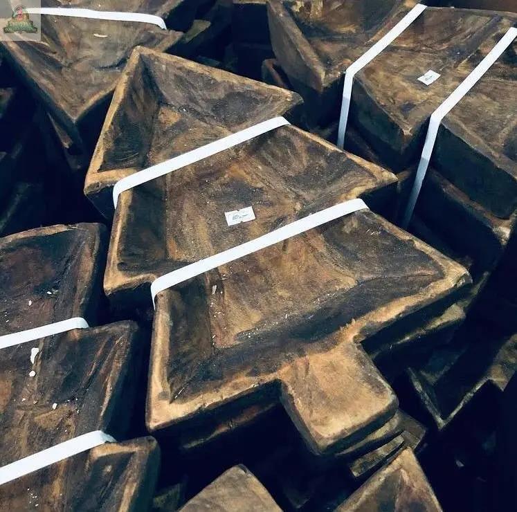 A close-up of several stacked Tree Dough Bowl, Handmade, #A—rustic wooden trays shaped like Christmas trees—secured with a white strap and a small price sticker.