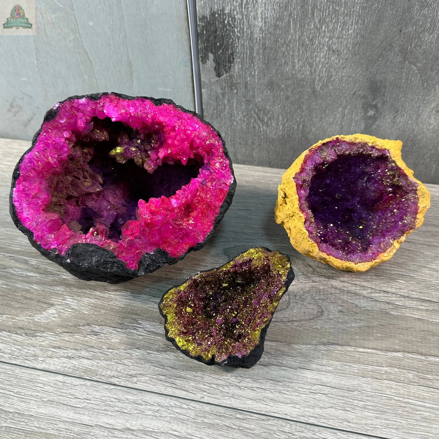 Keystone Crystals' Vibrant Dyed Geode Pairs from Pink Platypus Emporium feature partially open Moroccan geodes with pink, yellow, purple, and green crystal hues—perfect for adding sparkling, natural décor to any space.