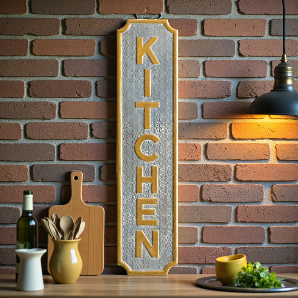 Decorative 'KITCHEN' sign on a brick wall with kitchen items below.