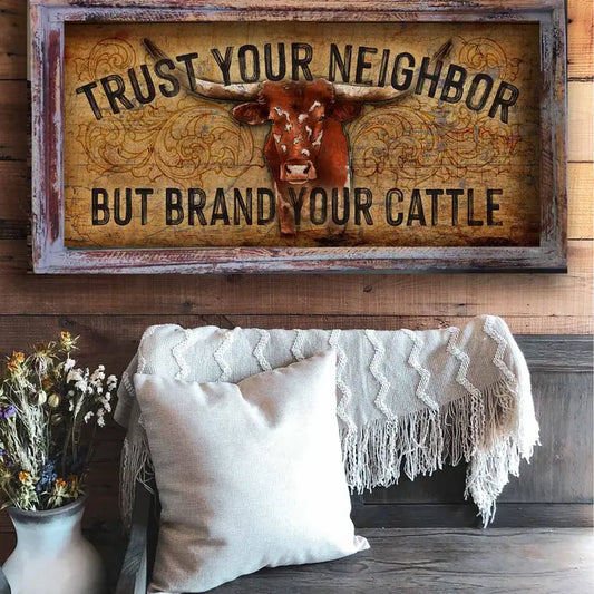 western wall decor with cow illustration and text 'Trust your neighbor but brand your cattle' above a cozy living room setting.