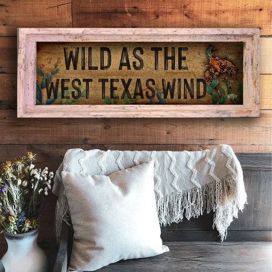 western wall decor with 'Wild as the West Texas Wind' text on a wooden wall above a couch.