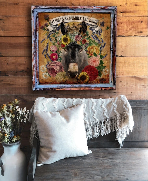 Decorative wall art with a donkey and floral elements on a wooden wall above a sofa.