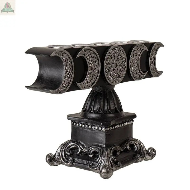 The Triple Moon Candleholder is a black and silver piece made from cold cast resin, featuring detailed triple moon motifs, a central pentagram, and an ornate pedestal base.