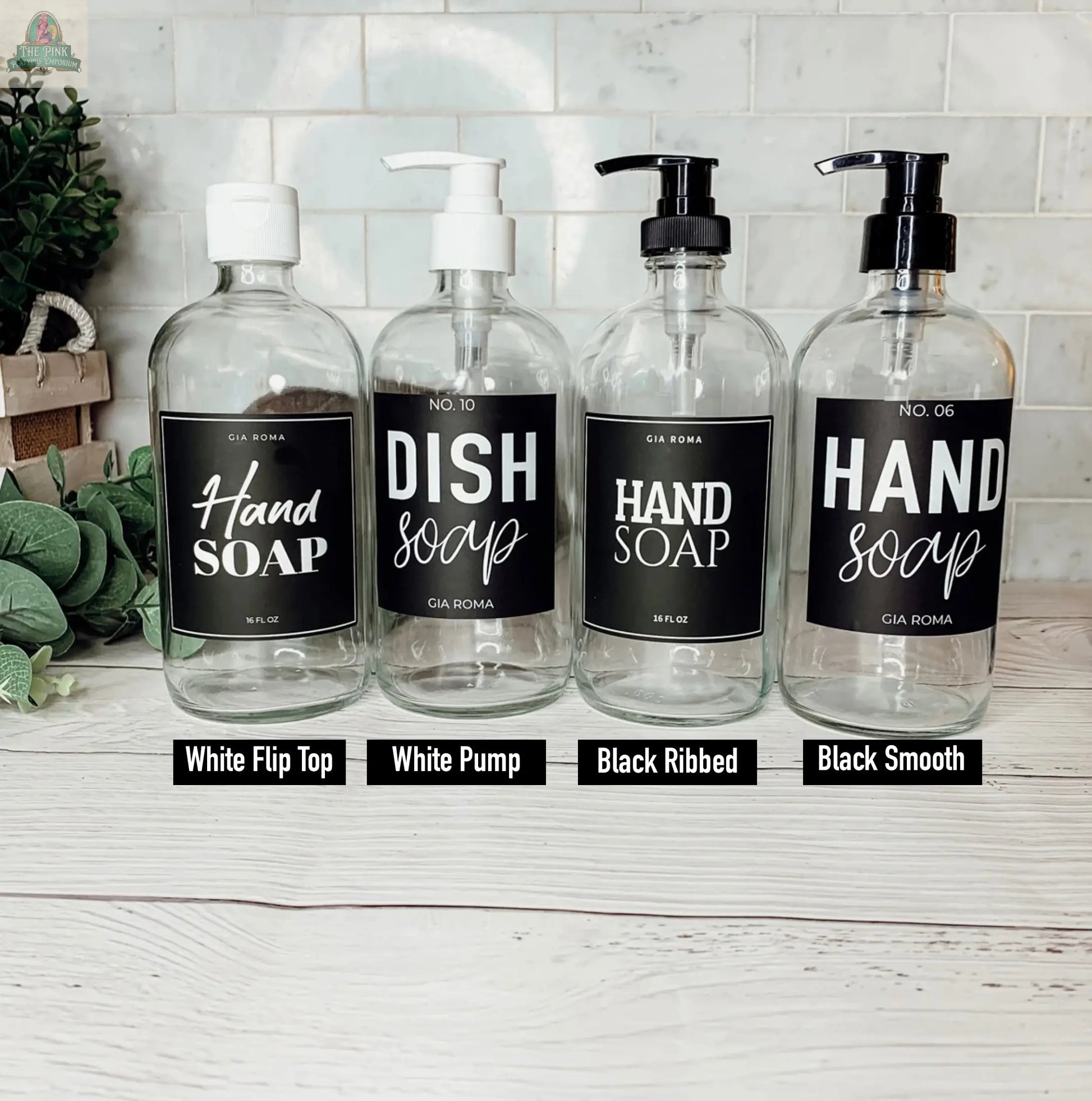 Four 16oz Glass Clear | White Label bottles serve as soap dispensers, each with a different pump style—white flip top, white pump, black ribbed, and black smooth—displayed on a white surface with waterproof labels.
