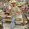 Person wearing a cowboy hat and oversized graphic tshirt in an outdoor setting