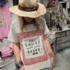 Person wearing a hat and a shirt with text saying "don't squat with your spurs on"