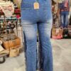 Person wearing a blue denim jeans with fringe on the sides 