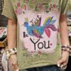 Person wearing a colorful boho bird graphic tee 