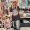 Person wearing a cowboy hat and patriotic 1776 graphic t-shirt in a store setting