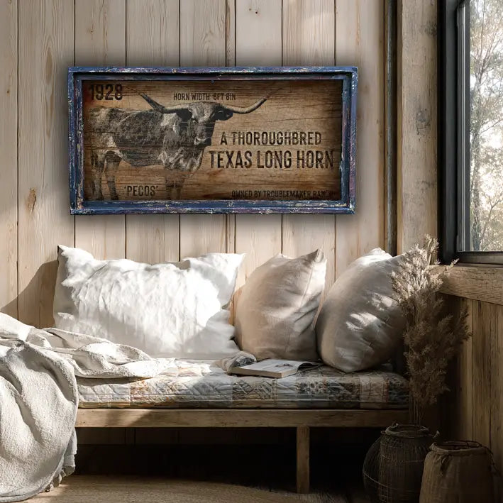 Rustic interior with a wooden bench, pillows, and a framed western wall decor Texas Longhorn sign on a wooden wall.