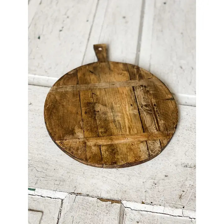 Wooden cutting board with handle on a white wooden surface
