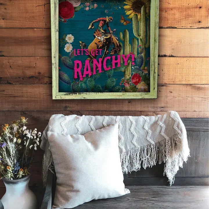 Decorative wall art with 'Let's Get Ranchy!' text on a wooden wall above a couch.