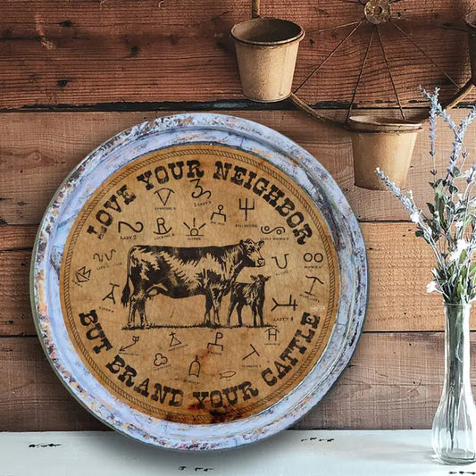 Decorative round sign with cow illustration and text on a wooden wall.