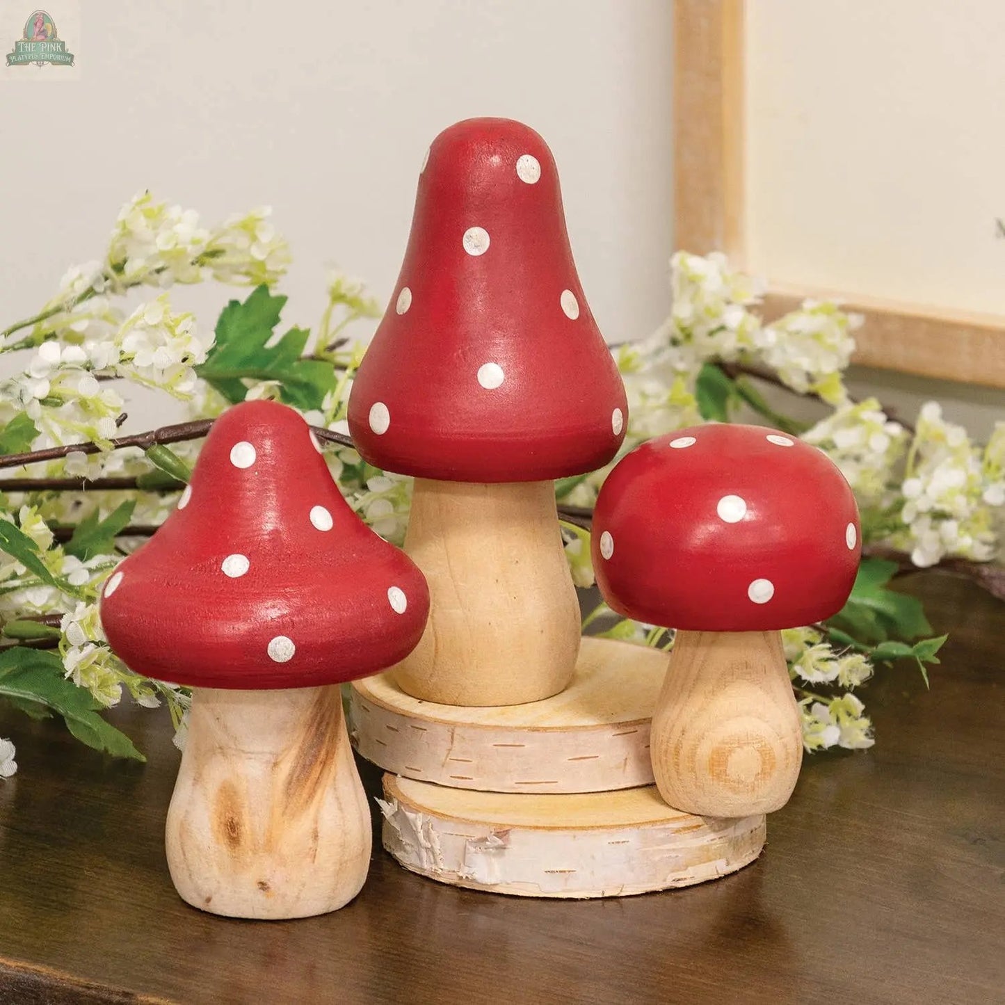 The 3/Set - Red & White Dotted Wooden Mushrooms features three decorative wooden mushrooms with red and white caps, perfect for charming spring decor and displays among flowers and greenery. Pink Platypus Emporium