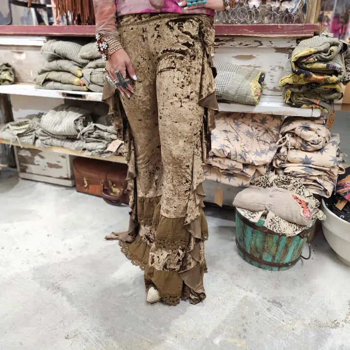 Person wearing a Brown Velvet Butterfly Ruffle Leggings for Women standing in a market setting with various fabrics and items.