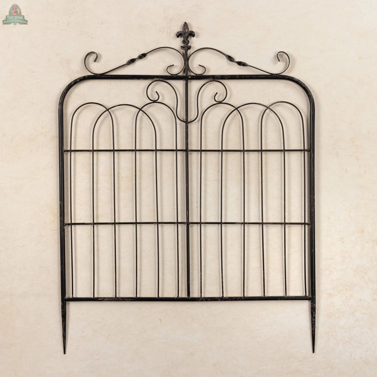 The 32" Aged Black Garden Gate features decorative scrollwork, a fleur-de-lis top ornament, and is photographed against a plain beige background.
