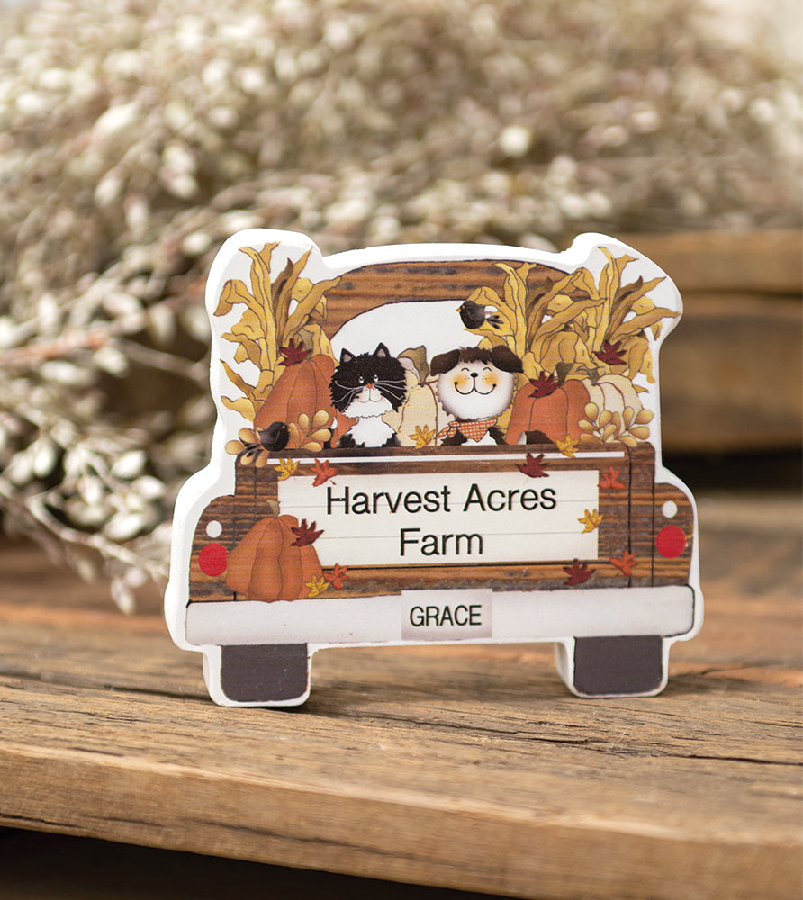 A die-cut wooden sign shaped like the back of a pickup truck, featuring autumn harvest illustrations including pumpkins, leaves, and two cats. The sign has a personalized nameplate reading 'Harvest Acres Farm' and 'GRACE' at the bottom, displayed on a rustic wooden surface with a blurred background.-Pink Platypus Emporium