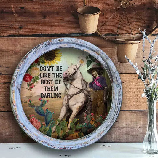 Decorative wall art with a cowgirl on a horse and text on a wooden background