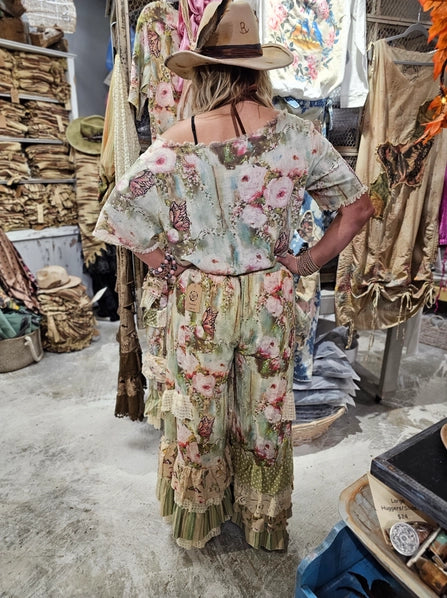Person wearing a boho western floral dress and hat in a clothing store