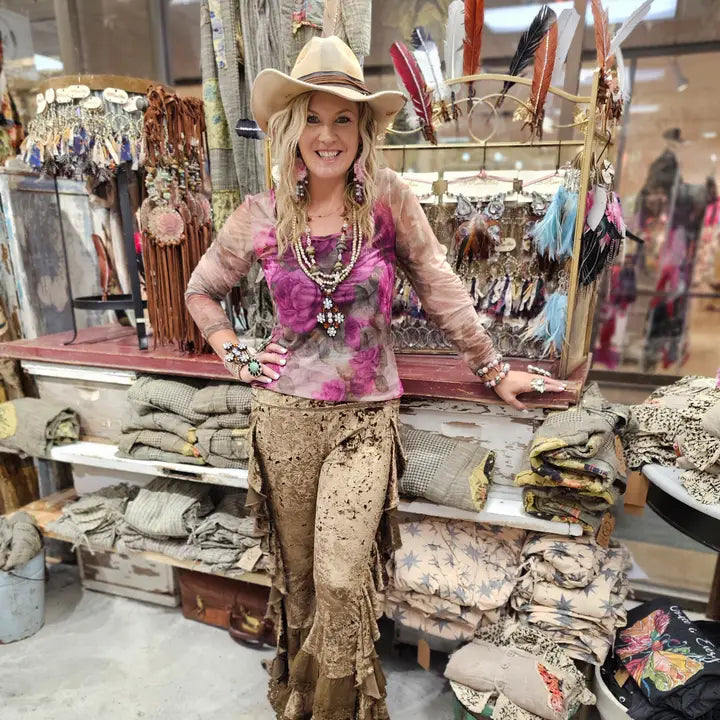 Woman in a store wearing a cowboy hat and Brown Velvet Butterfly Ruffle Leggings for Women with a background of merchandise.