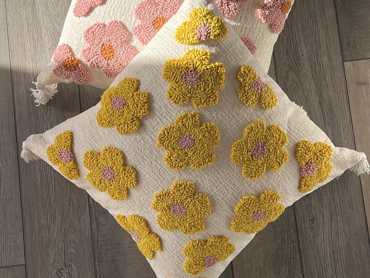 Decorative pillow with yellow flower patterns on a wooden surface