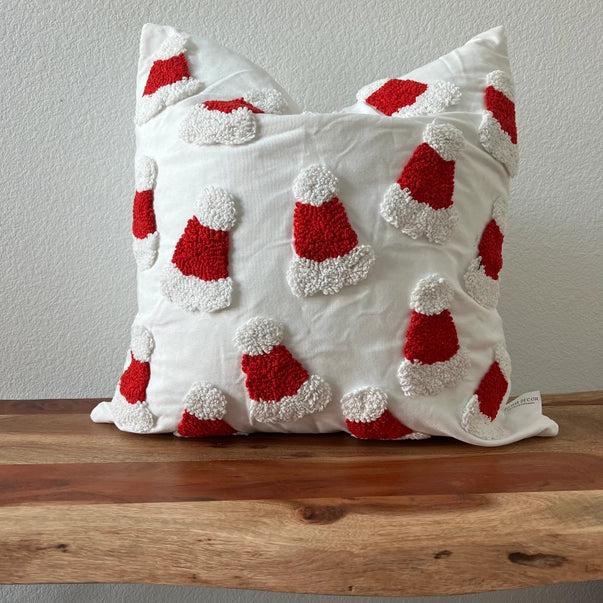 Decorative pillow with red and white patterns on a wooden surface