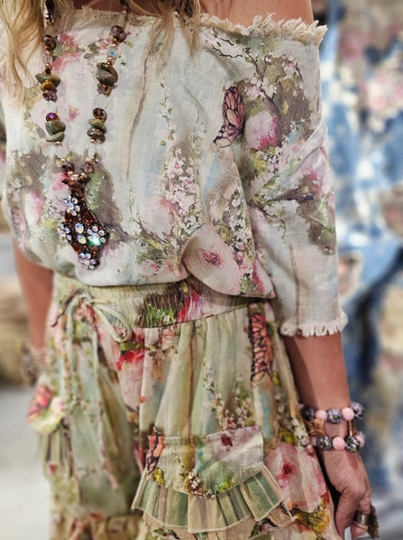 Floral patterned outfit with jewelry and bracelets on a blurred background