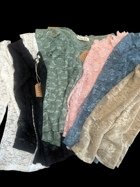Collection of lace layering tops in various colors on a black background